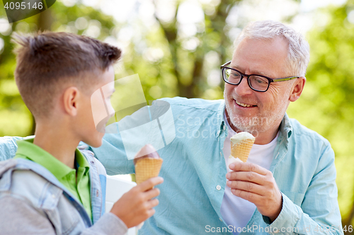 Image of old man and boy eating ice cream at summer park