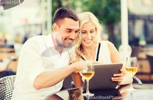 Image of happy couple with tablet pc at restaurant lounge