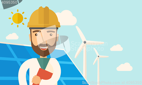 Image of Man in solar panel and windmills.