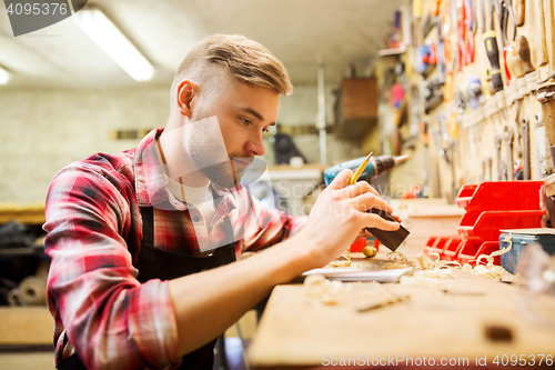 Image of carpenter working with wood plank at workshop