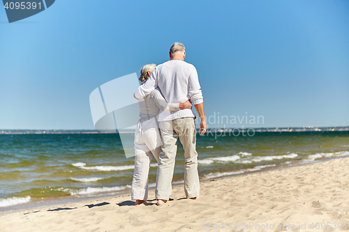 Image of happy senior couple hugging on summer beach