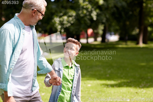 Image of grandfather and grandson walking at summer park