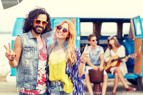 Image of hippie friends over minivan car showing peace sign