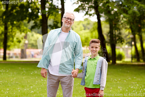 Image of grandfather and grandson walking at summer park