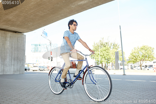 Image of young hipster man riding fixed gear bike