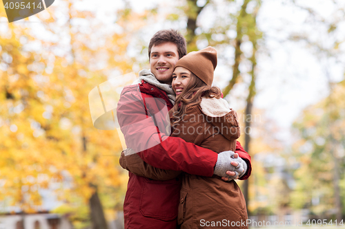 Image of happy young couple hugging in autumn park
