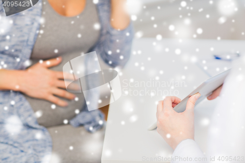 Image of close up of doctor with tablet and pregnant woman