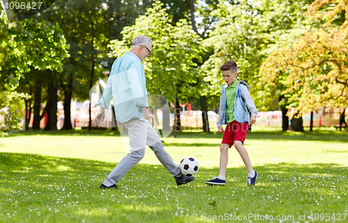 Image of old man and boy playing football at summer park