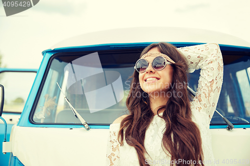 Image of smiling young hippie woman in minivan car