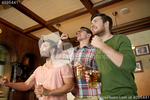 Image of friends with beer watching sport at bar or pub