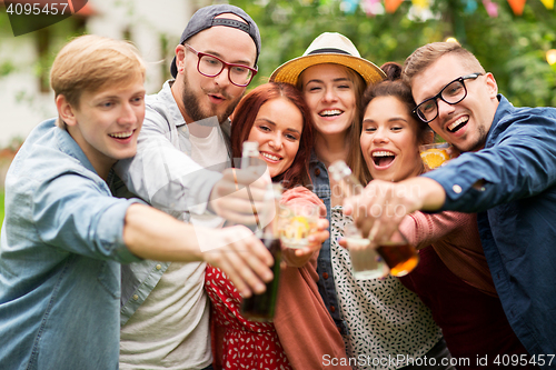 Image of happy friends clinking glasses at summer garden