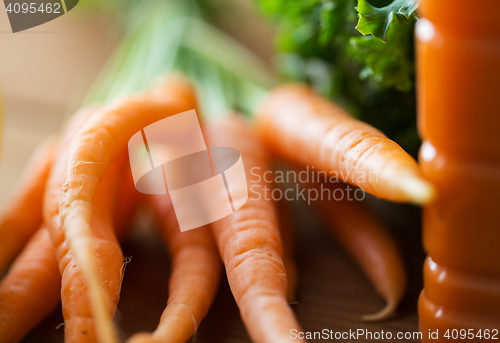 Image of close up of carrot bunch on wooden table