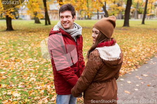 Image of happy young couple walking in autumn park