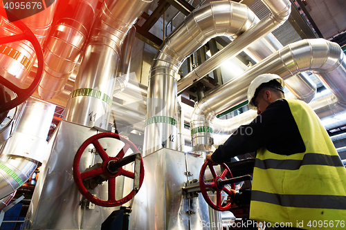 Image of factory worker turning valve