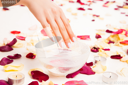 Image of Female gentle hand on bowl with water