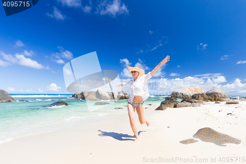 Image of Woman enjoying white sandy beach on Mahe Island, Seychelles.