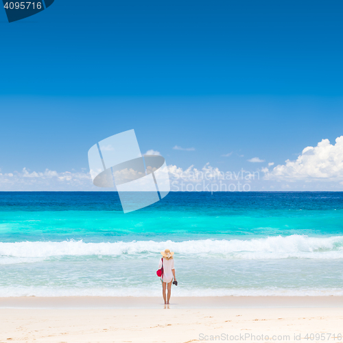 Image of Woman enjoying picture perfect beach on Mahe Island, Seychelles.