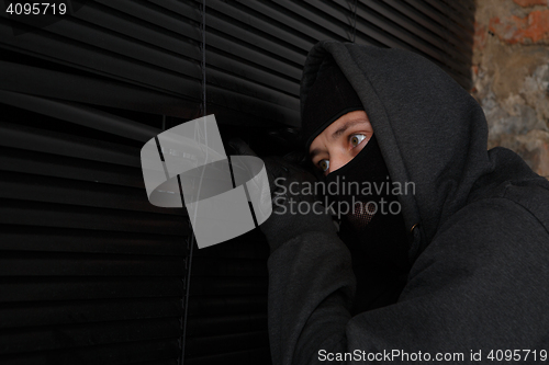 Image of Burglar peeping into closed window