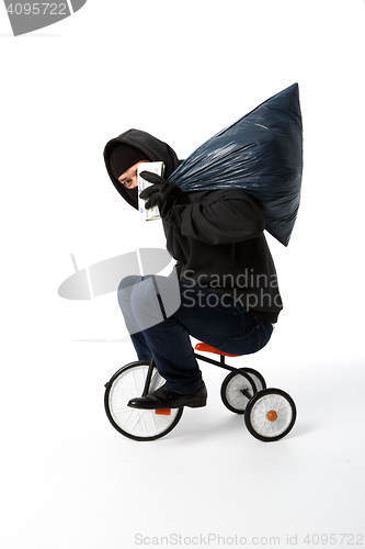 Image of Robber goes on small bike