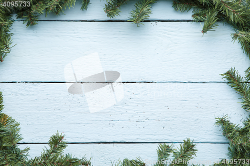 Image of New year and christmas light blue wooden background with evergreen