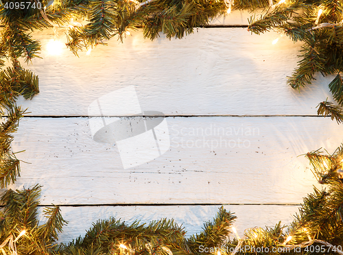 Image of Christmas background with fir tree and lightbulb on wooden board