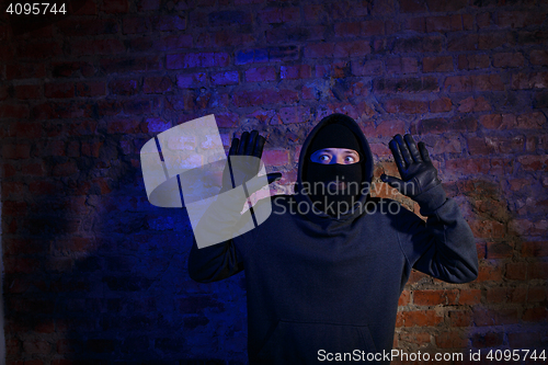 Image of Surprised thief with arms raised