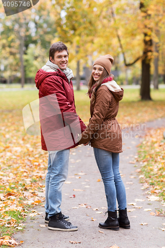 Image of happy young couple walking in autumn park