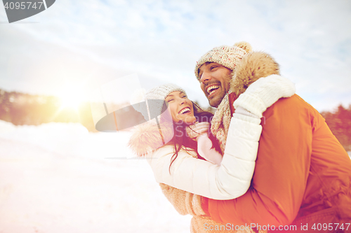 Image of happy couple hugging outdoors in winter