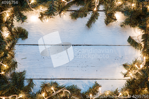 Image of Christmas empty card with blue wooden texture illuminated light bulbs