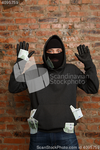 Image of Burglar with banknotes in pockets