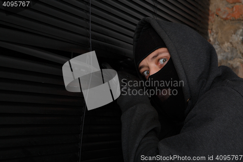 Image of Thief in black mask peeking