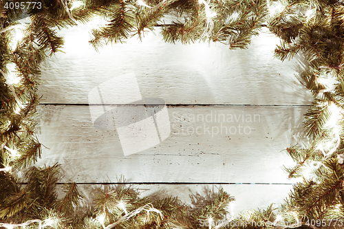 Image of Xmas, new year wooden background with garland and fir tree