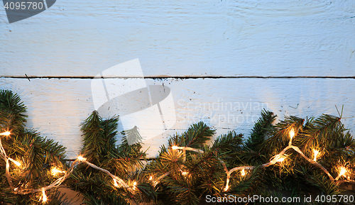 Image of Christmas lighted fir tree over wooden background with copyspace