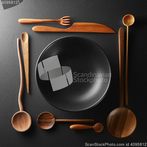 Image of frame of setting empty plate and wooden cutlery