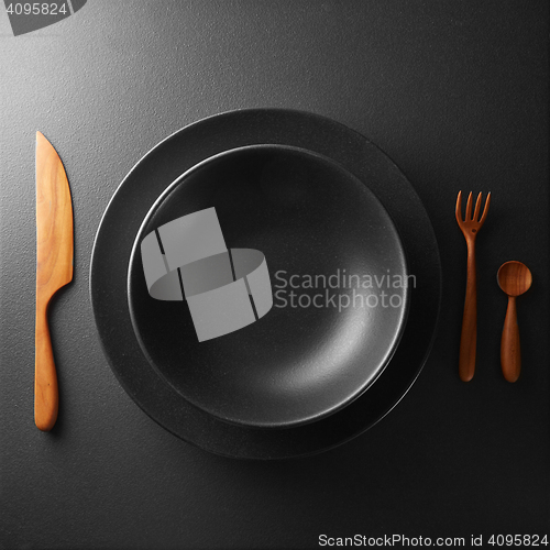 Image of plate and cutlery on a black table