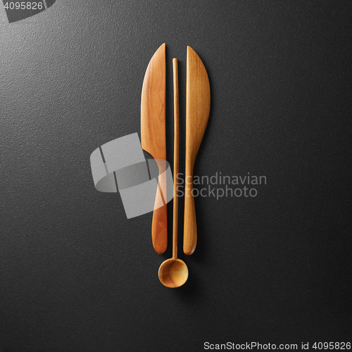 Image of Top view of black alarm clock with wooden knife