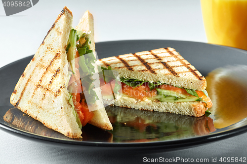 Image of sandwich with salmon and orange juice for breakfast