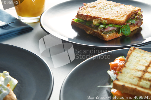 Image of breakfast of eggs, sandwiches and orange juice