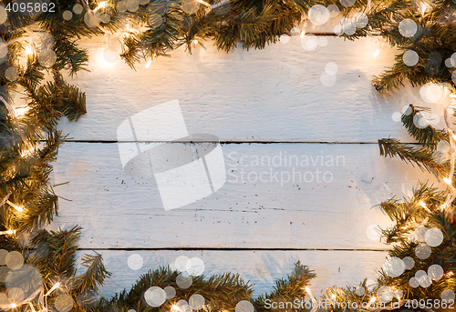 Image of Christmas wooden bokeh background with fir tree and lighted garladnd