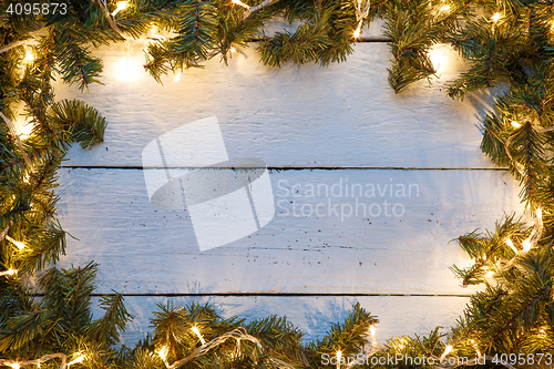 Image of Christmas, new year wooden background with spruce branches and garland