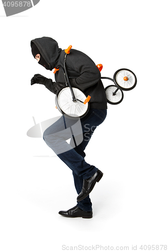 Image of Burglar stealing small children\'s bicycle