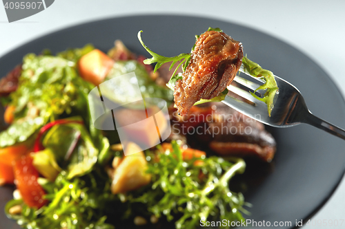 Image of baked pumpkin, steak and arugula on a fork