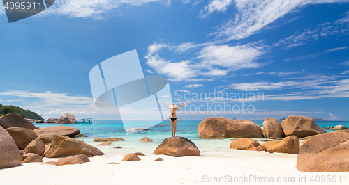 Image of Woman enjoying Anse Lazio picture perfect beach on Praslin Island, Seychelles.