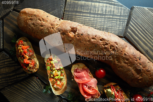 Image of mini bruschetta with tomatoes, salmon, avocado, bacon, and basil butter