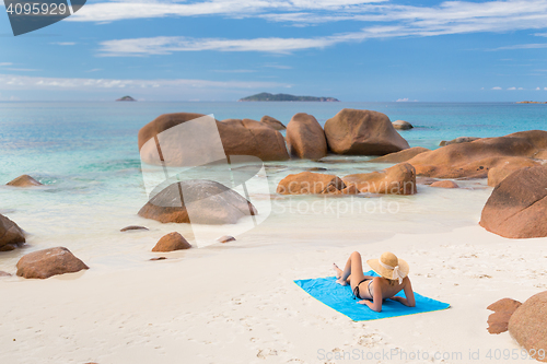 Image of Woman sunbathing at Anse Lazio picture perfect beach on Praslin Island, Seychelles.