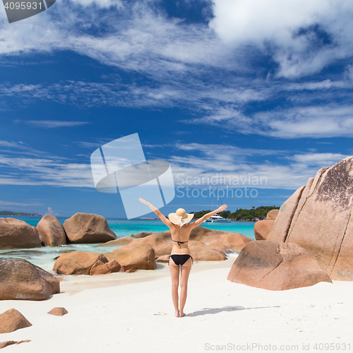 Image of Woman enjoying Anse Lazio picture perfect beach on Praslin Island, Seychelles.