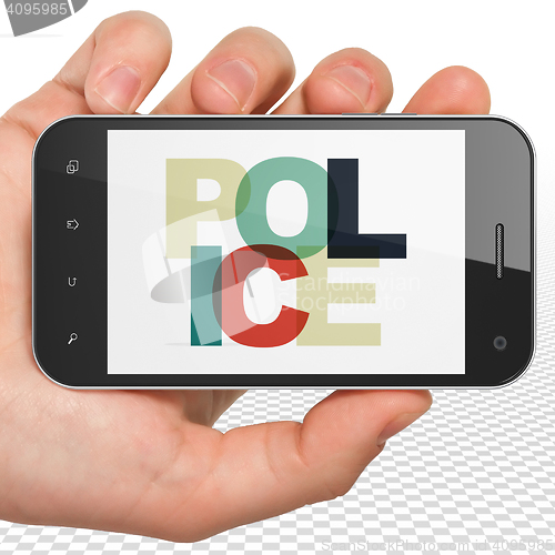 Image of Law concept: Hand Holding Smartphone with Police on  display