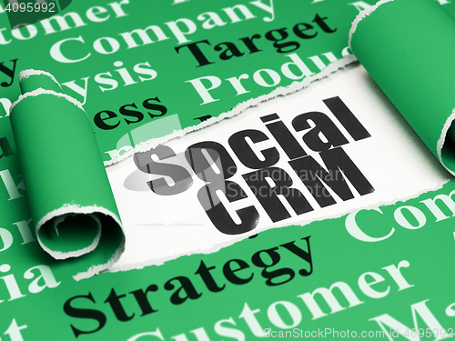 Image of Marketing concept: black text Social CRM under the piece of  torn paper