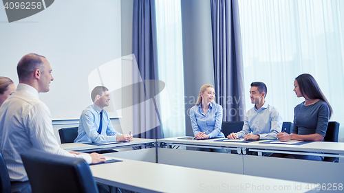 Image of group of smiling businesspeople meeting in office