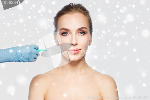 Image of woman face and hand with syringe making injection